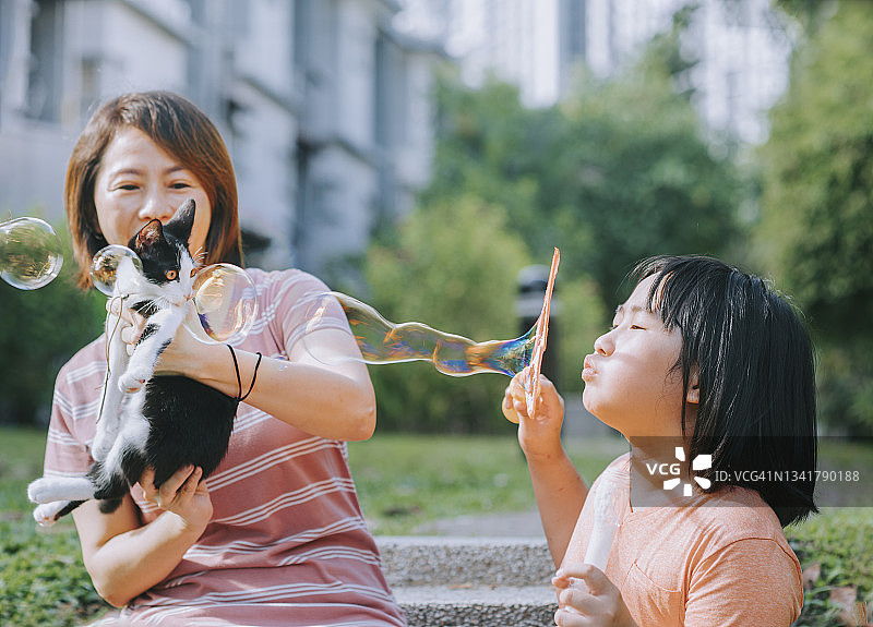 中国母女在后院和猫玩泡泡图片素材