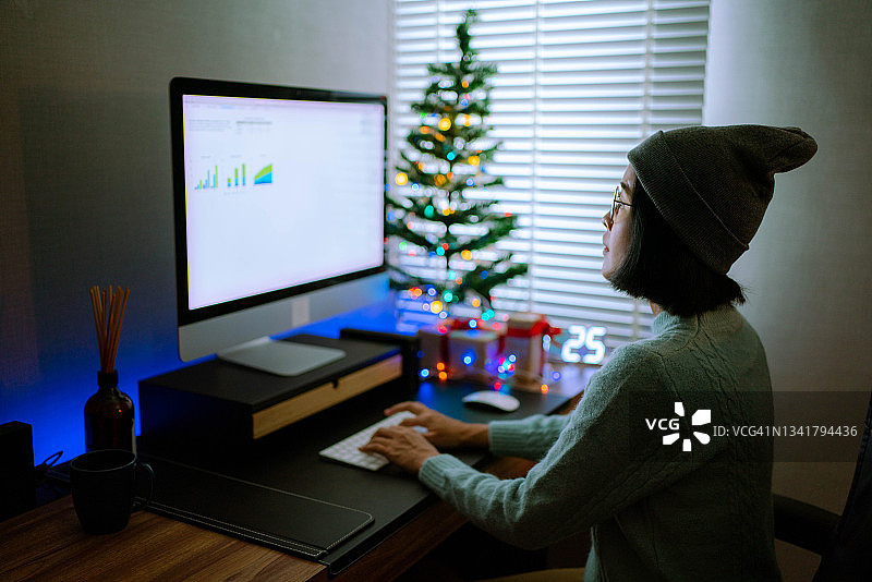 自由职业者亚洲女性在圣诞节期间在家使用电脑工作图片素材