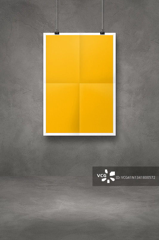 用夹子挂在深色混凝土墙上的黄色折叠海报图片素材