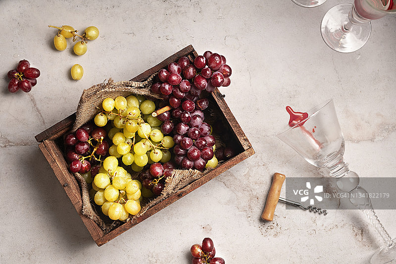 装有红白葡萄和精美葡萄酒杯的木制篮子图片素材