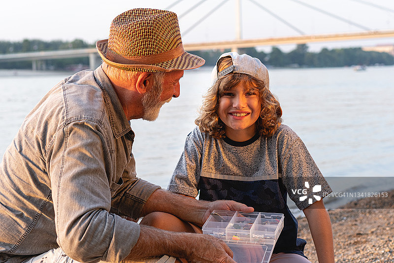 可爱的男孩与爷爷在河边度过美好的一天，难掩喜悦图片素材