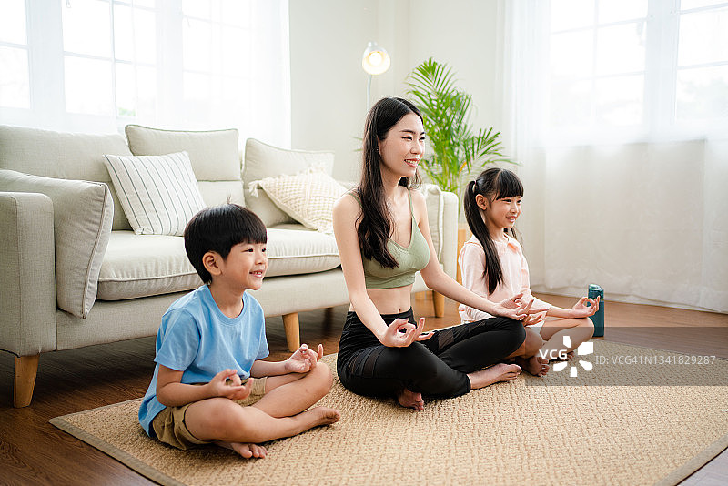 年轻的母亲和孩子在家做运动图片素材