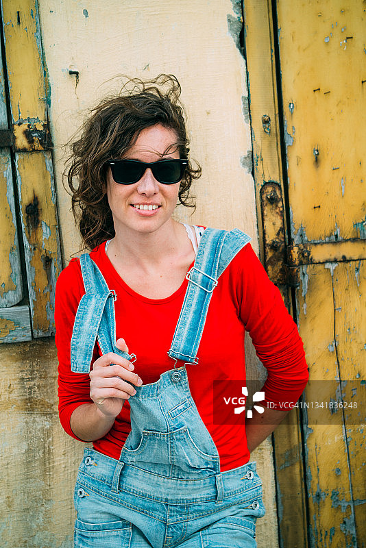 穿着牛仔连体裤的漂亮年轻女人图片素材