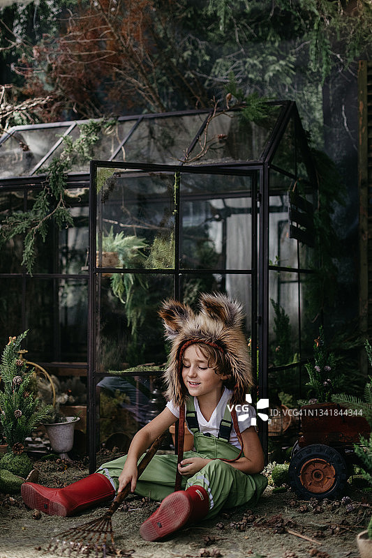 男孩戴着狐狸帽子在花园里玩耍图片素材