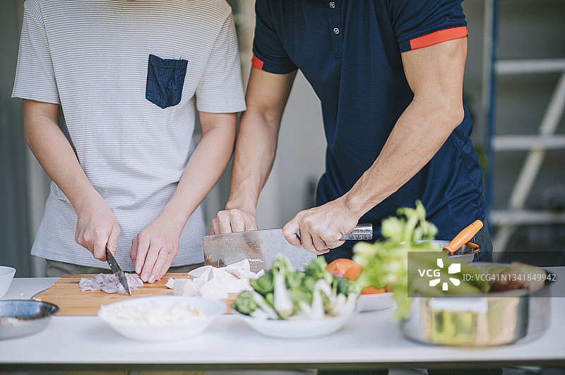 亚洲华人父子在厨房准备晚餐特写图片素材