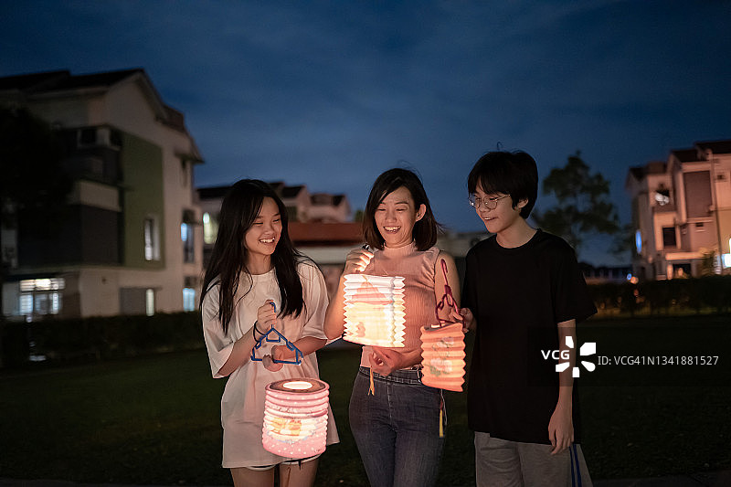 华人母亲和孩子们手持纸灯笼庆祝中秋节图片素材
