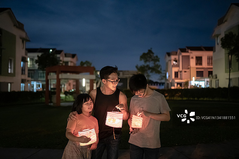亚洲华裔父亲与孩子和侄子拿着纸灯笼庆祝中秋节图片素材