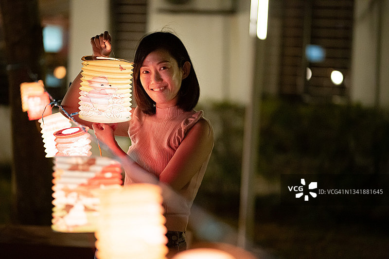 亚洲中国妇女展示纸灯笼，庆祝中秋节图片素材