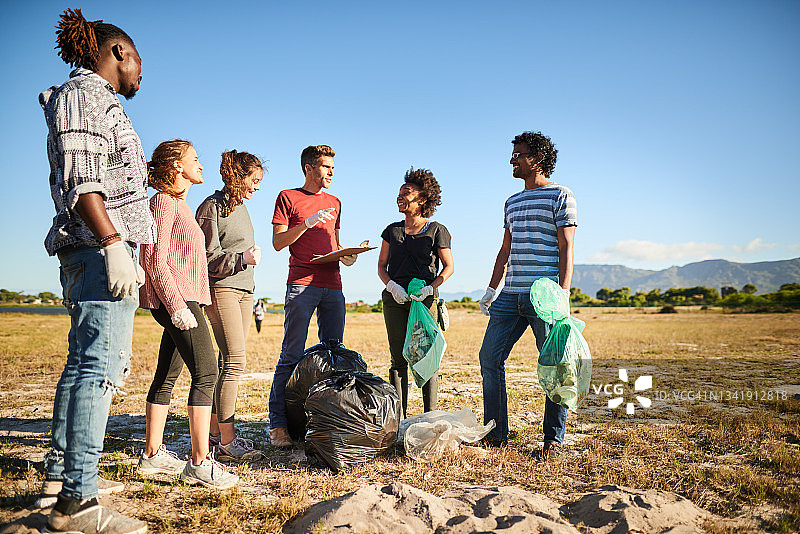 在社区清理日，年轻人给志愿者分配任务图片素材