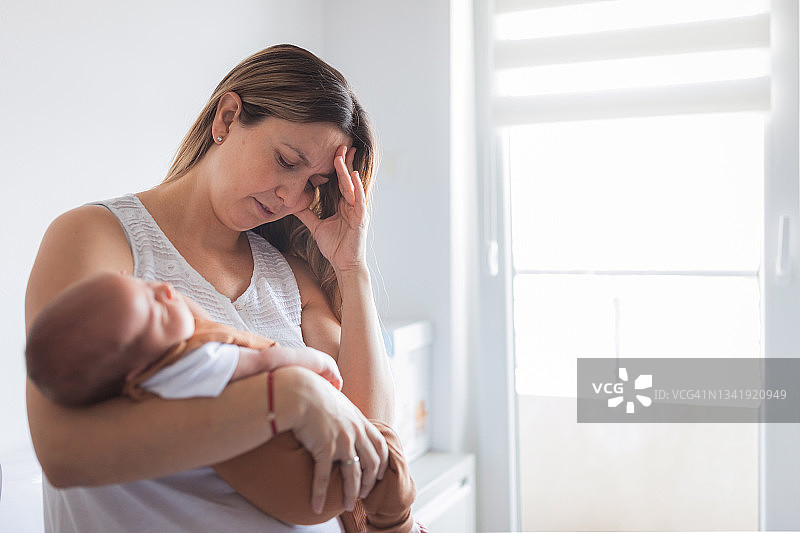 患有产后抑郁症的妇女哄新生儿入睡图片素材