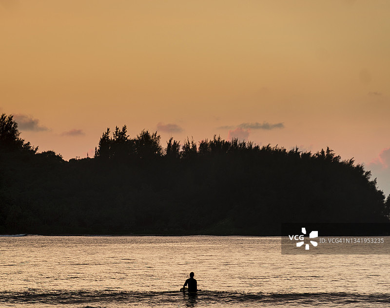 日落时分等待海浪的冲浪者剪影图片素材