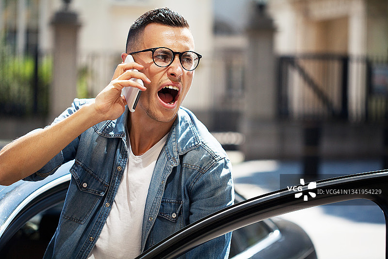 愤怒的年轻男人正在打电话图片素材