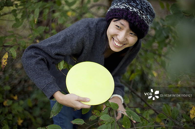 年轻亚裔女性在马里兰州巴尔的摩打飞盘高尔夫图片素材