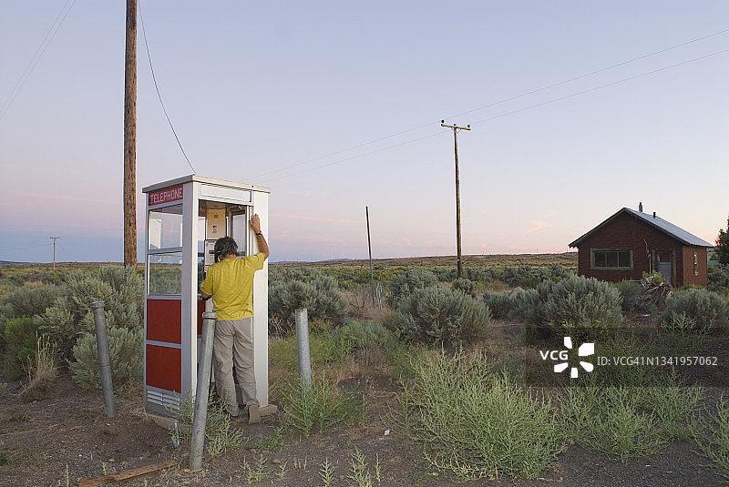 男子在独立的电话亭里打电话图片素材