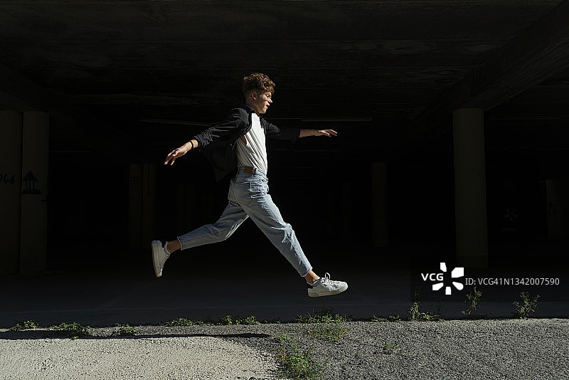 在黑色背景下奔跑跳跃的年轻人图片素材