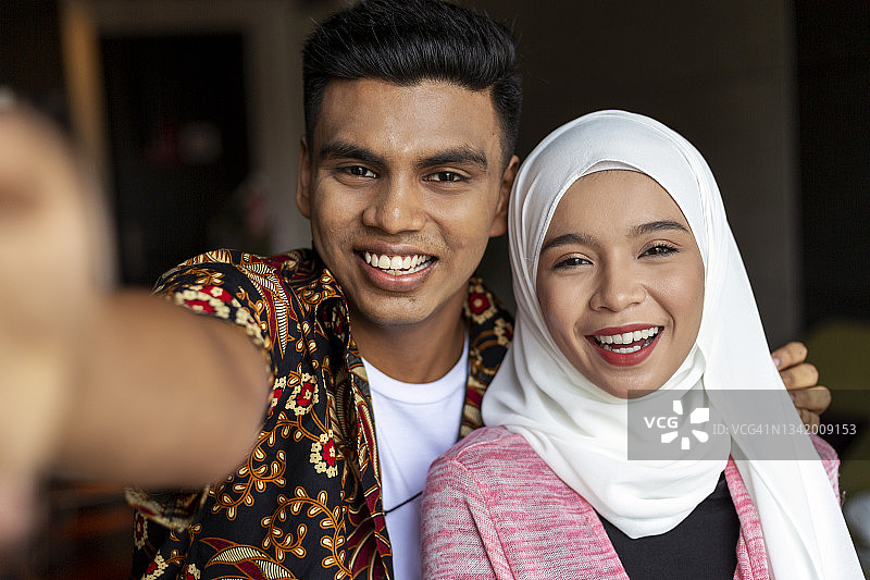 快乐的年轻穆斯林夫妇在家自拍图片素材