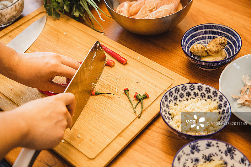 在厨房切辣椒的亚洲女人（用新鲜食材准备健康的亚洲食物）图片素材