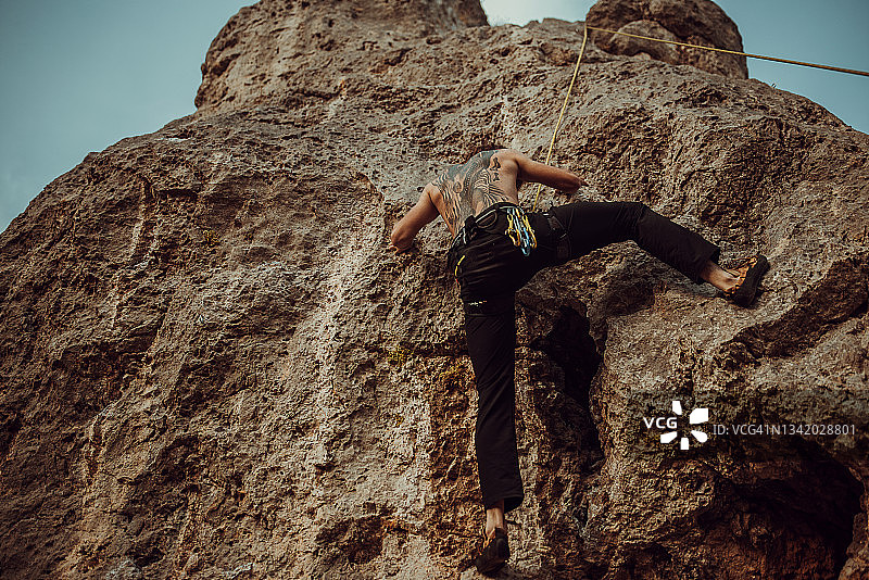 男人在悬崖上攀岩图片素材