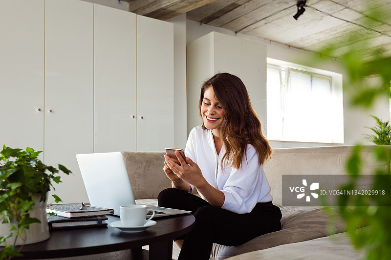 在绿色办公室工作的快乐年轻女子图片素材