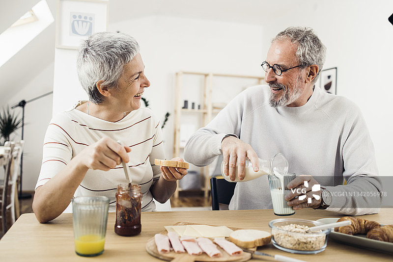 快乐的老年夫妇共进早餐，享受清晨图片素材