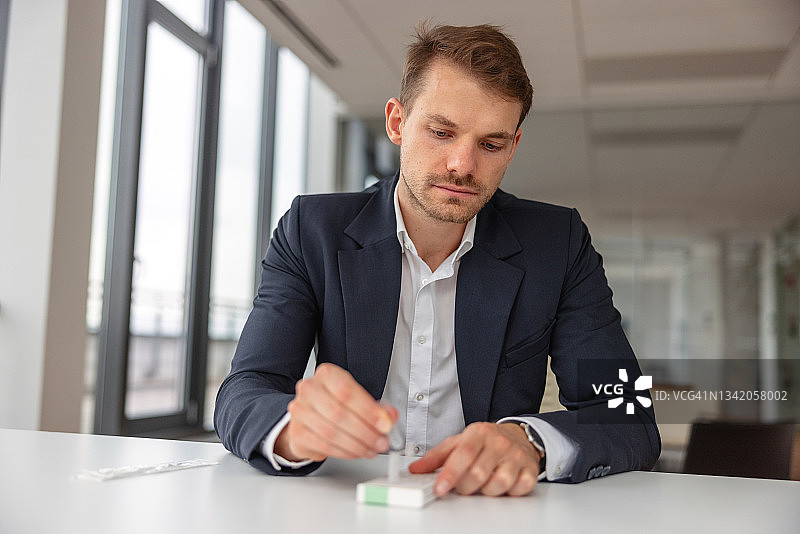 商人将测试样本应用于COVID-19自检试剂盒图片素材