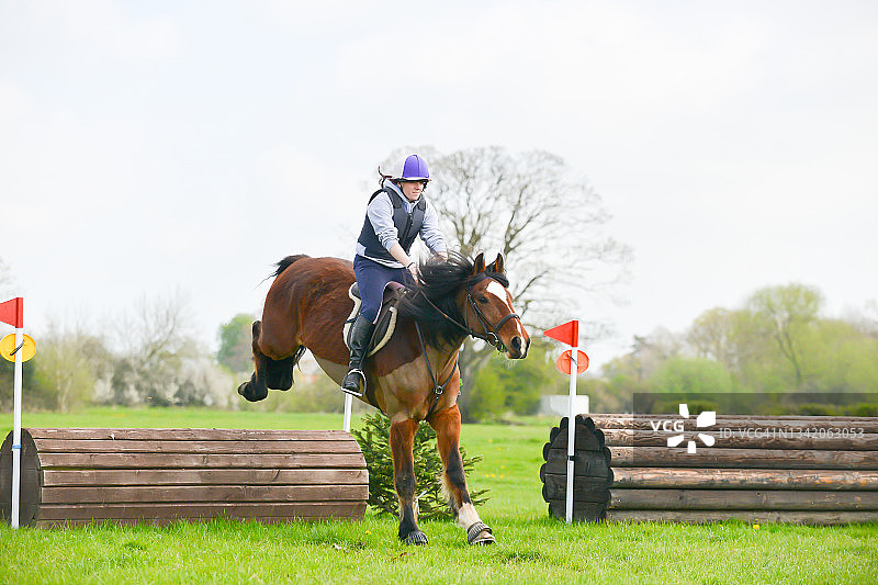 年轻骑手和她的马在美丽的什罗普郡乡村参加越野比赛图片素材