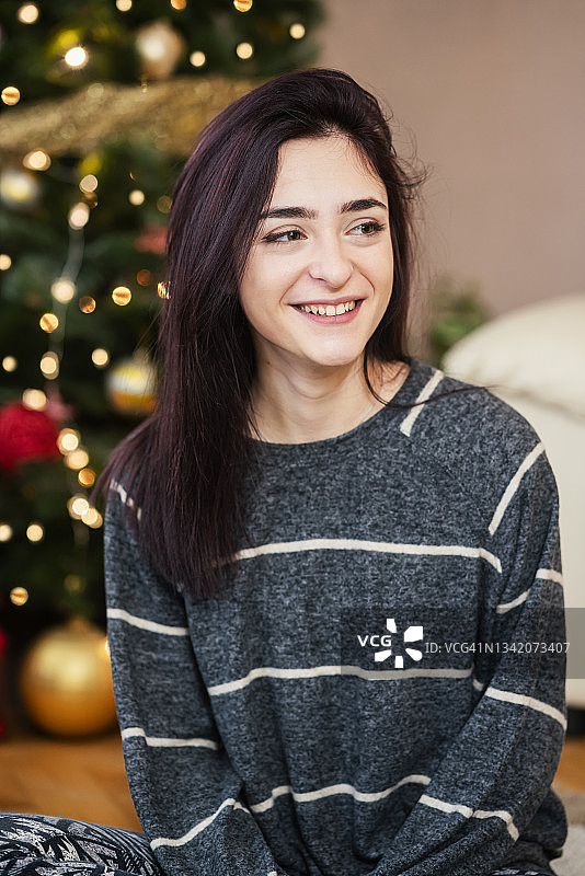 圣诞树前的年轻女子肖像图片素材