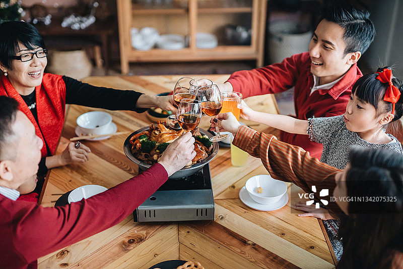 三代亚洲家庭喜庆中国新年，品尝盆菜共庆团圆图片素材