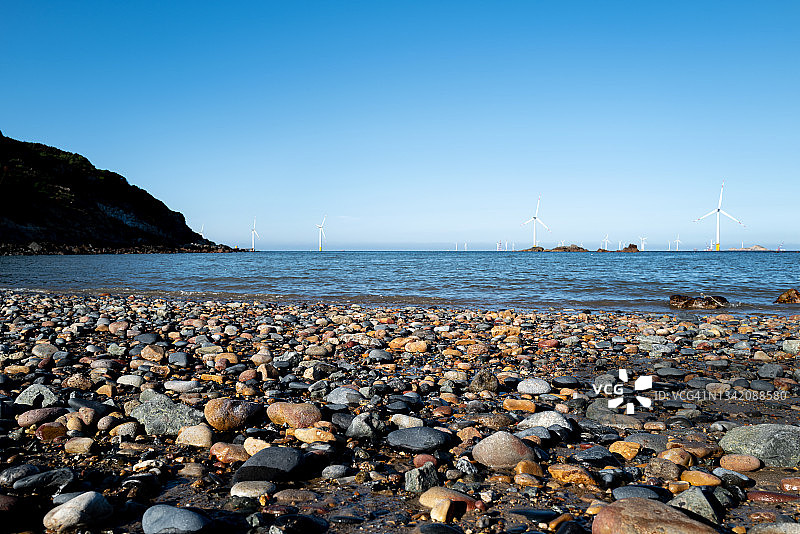 阳光明媚的日子里鹅卵石海滩的仰视角度照片图片素材