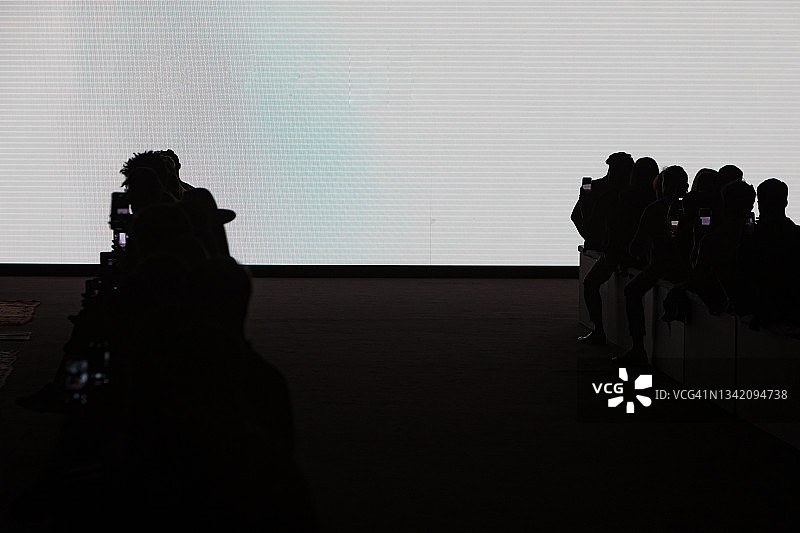 巨型屏幕发光人们用手机拍摄图片素材