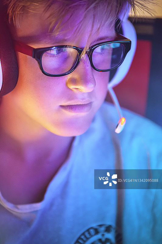 戴着耳机的电脑旁的小游戏玩家图片素材