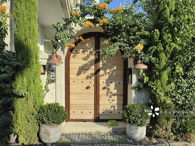 带有橙色花朵和石墙的木门图片素材