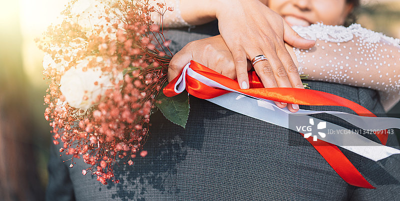 穿白色婚纱的新娘拥抱穿灰色西装的丈夫图片素材