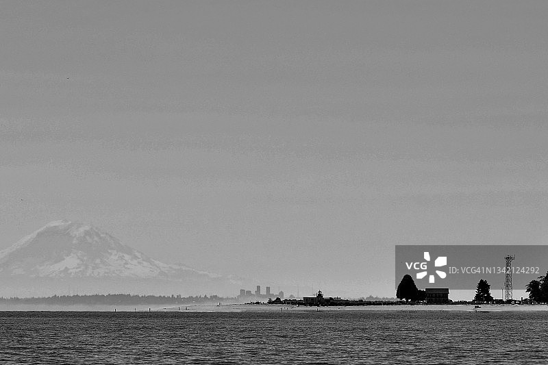 城市天际线和海滩上方的火山图片素材
