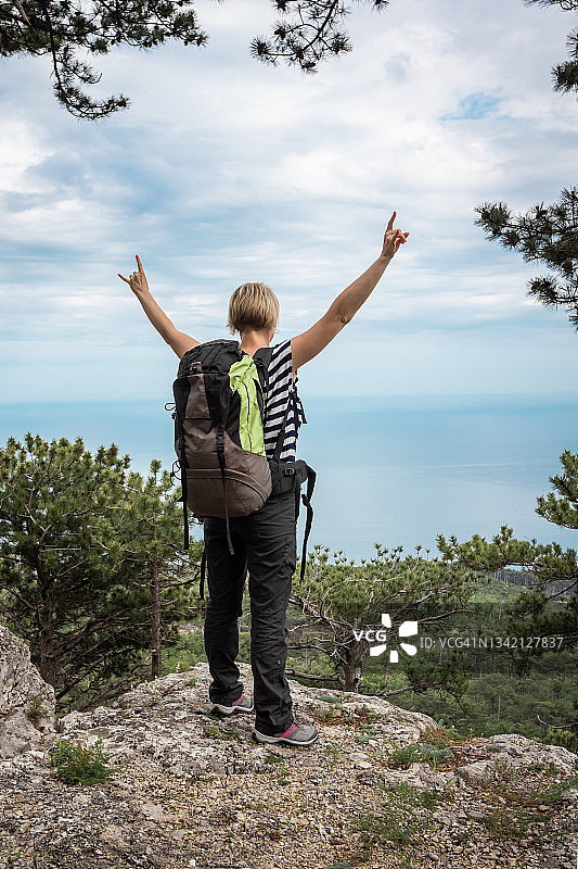 快乐的女人背着背包举手观望图片素材