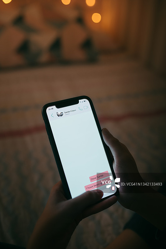 用手机给圣诞老人发圣诞祝福短信的小女孩图片素材