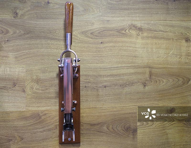 棕色纹理墙中嵌入的木质金属拔塞钻正面特写图片素材