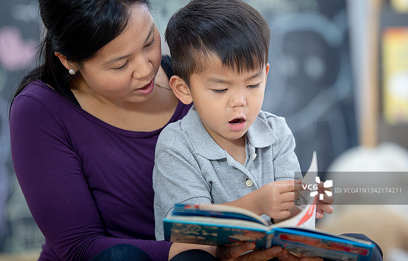 小男孩和妈妈一起翻书图片素材