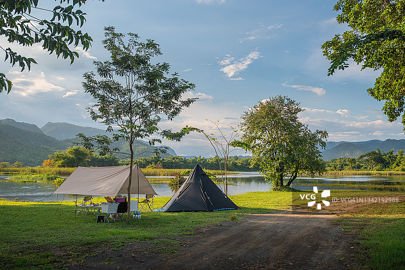 绿色草原日出时的帐篷与山景图片素材