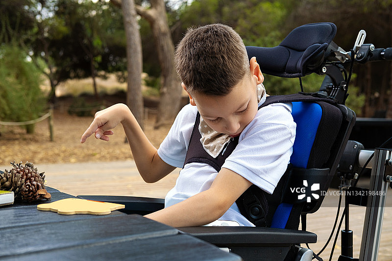 坐在轮椅上的可爱脑瘫男孩图片素材