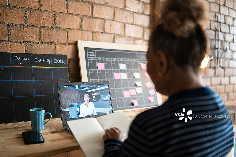 年长的女人在工作中通过笔记本电脑进行视频通话图片素材