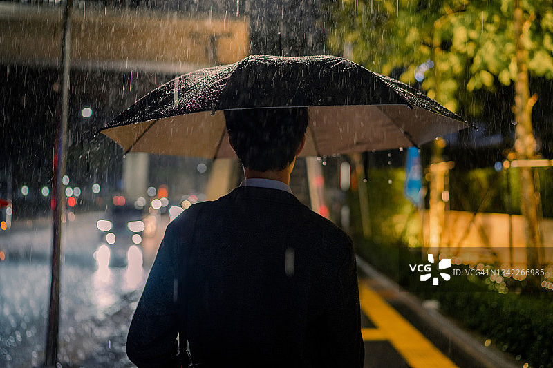 在雨中等公共汽车的男人图片素材