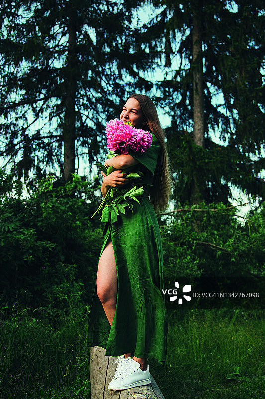 年轻女子手捧鲜花微笑的夏日生活写真图片素材