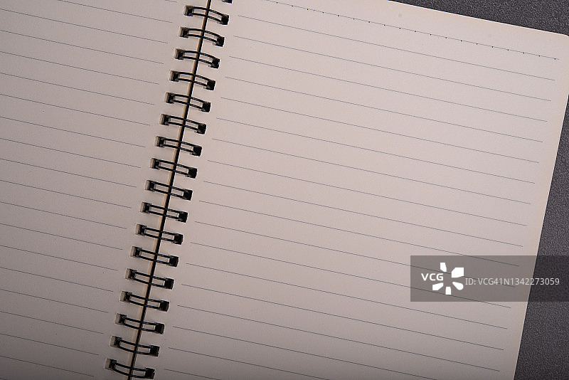 打开的学校笔记本俯视图，空白页用于在木桌背景上做笔记。创意工作区办公室平面布置。带有复制空间的商业教育概念。图片素材