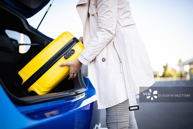 女人将行李装进汽车图片素材