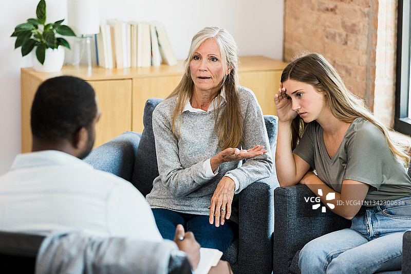沮丧的母亲与顾问谈论女儿的态度图片素材