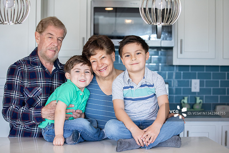 爷爷奶奶在厨房里与小孙子们合影，笑容慈爱图片素材