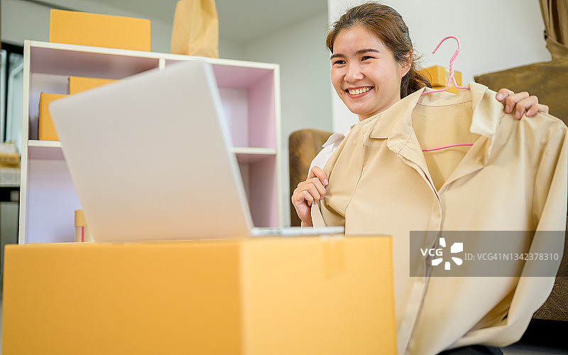 美丽的亚洲女性博主在镜头前展示服装，录制vlog直播视频图片素材