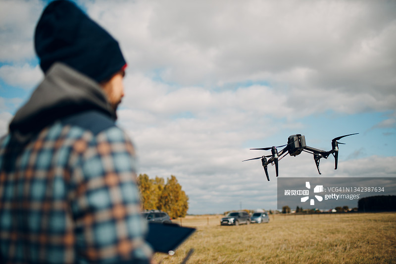 男人使用遥控器控制四轴飞行器图片素材