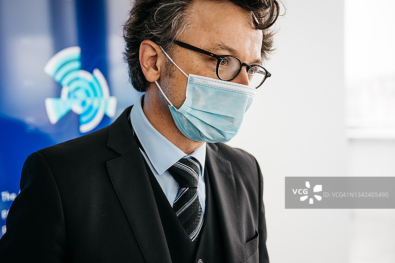 佩戴外科口罩的商人特写图片素材